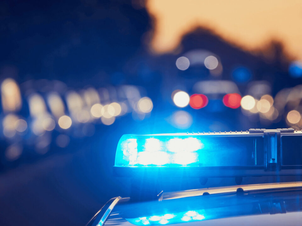 a close up of a police car with its lights on stopping a driver who bought a stolen vehicle from a dealership